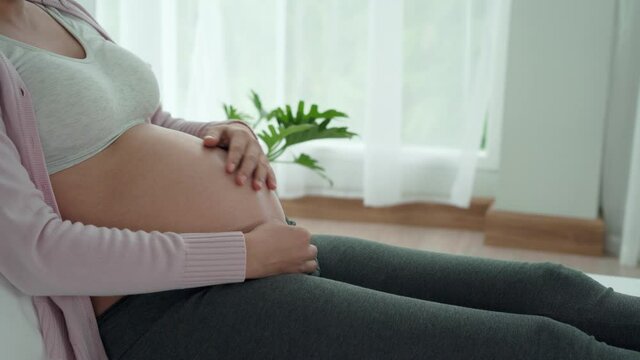 Pregnant concept. Pregnant women use hand touch on stomach during 8 months of pregnancy. Patting the belly while pregnant is a common gesture of gestures to capture the reactions of the unborn child.