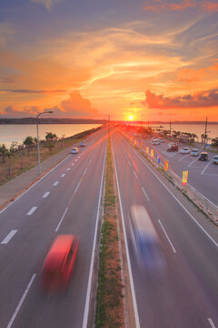 ロードパークの歩道橋上から望む本島側の海中道路と夕日, うるま市,沖縄県