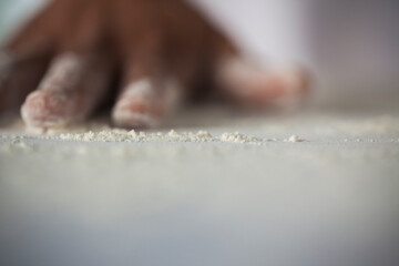 Human Hand making pasta - making Raw and dry pasta on kitchen table - flower