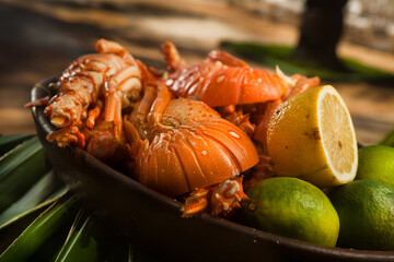 Delicious fresh and cooked whole lobster with lime, lemon on a banana leaf. High quality photo