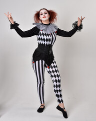   halloween, character, costume, figure pose, posing, portrait, gesture,  isolated,  magical, dynamic movement,  isolated,  studio background,  red hair, circus, theatre, jester, clown,  
full length,