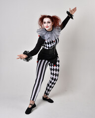   halloween, character, costume, figure pose, posing, portrait, gesture,  isolated,  magical, dynamic movement,  isolated,  studio background,  red hair, circus, theatre, jester, clown,  
full length,