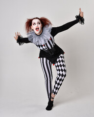   halloween, character, costume, figure pose, posing, portrait, gesture,  isolated,  magical, dynamic movement,  isolated,  studio background,  red hair, circus, theatre, jester, clown,  
full length,