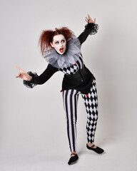   halloween, character, costume, figure pose, posing, portrait, gesture,  isolated,  magical, dynamic movement,  isolated,  studio background,  red hair, circus, theatre, jester, clown,  
full length,