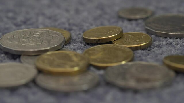 Coins falling onto the carpet, extreme close up of Australian coins, macro 4K