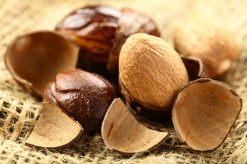 Organic sun dried nutmeg, Indian spices background.