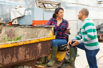 Farm workers have a dialogue next to the tractor