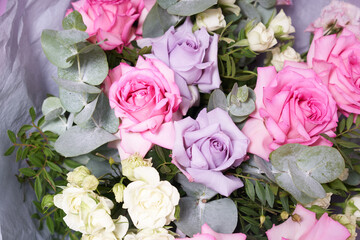 A large colorful bouquet of flowers. Large pink roses and eucalyptus leaves. On a light background, side view. The concept of the holiday. High quality photo