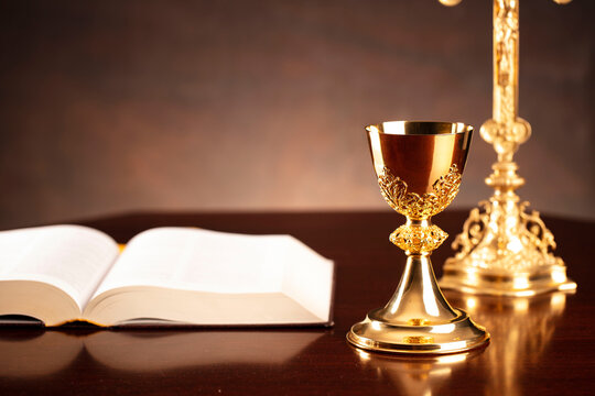 All Saints day. Catholic religion concept. The Cross,  Holy Bible and golden chalice on the altar. 