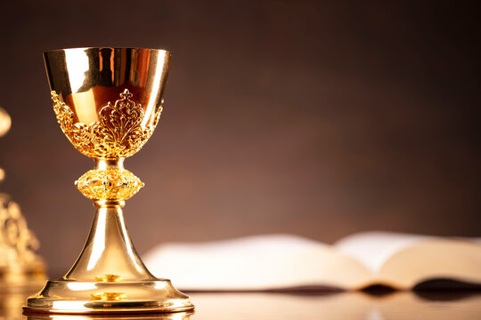 All Saints day. Catholic religion concept. The Cross,  Holy Bible and golden chalice on the altar. 