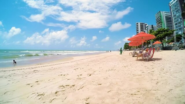 Time-lapse video of the morning at the beach of Boa Viagem. Bathers and vendors on the beach. People enjoying the day at the beach on a beautiful sunny day.