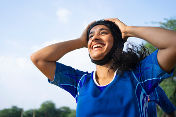 Young girl smiling with her hand on the helmet