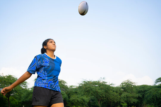 Young athlete girl practicing rugby on the sports field