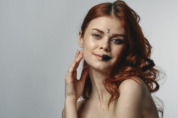 red-haired woman naked shoulders zodiac sign on face gemini