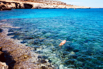 Girl swims on her back in the Mediterranean Sea. Rest and relaxation concept