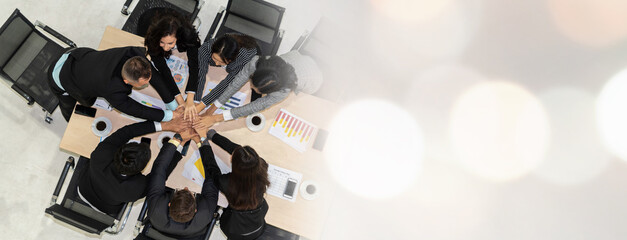 Happy business people celebrate teamwork success together with joy at office table shot from top...