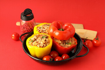 Concept of tasty food with stuffed pepper on red background