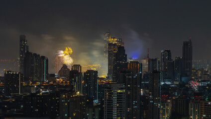 Fototapeta na wymiar Colorful Firework with cityscape night light view of Bangkok skyline at twilight time. New Year celebration fireworks, Bangkok city,Thailand Fireworks light up to sky at Christmas & New Year festival 