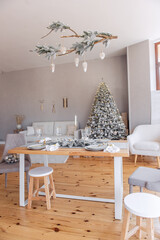 Stylish, trendy living room interior is festively decorated. Christmas tree under are gifts