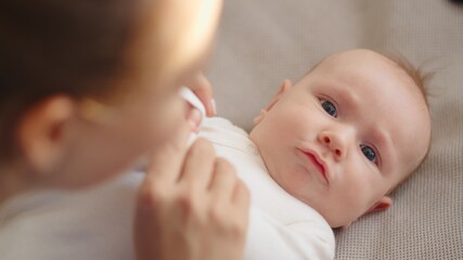 Newborn baby happy to looking on his mom . Happy mother spends time with her child. Mother playing with an infant kid.   Infant with blue eyes happy being with mama. Maternity and childcare concept.