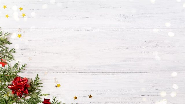 Flat lay of Christmas decorations on white wooden background with bokeh. Christmas tree branches with red gift ribbons and copy space