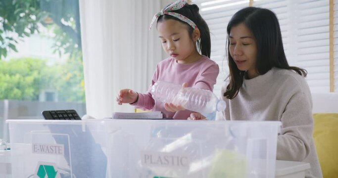 Mom teach Gen Z preteen girl kid dump paper glass can e-waste bag in reuse bin recycle bank help climate change social issue in asia people. Trash sorting clean eco green zero waste fun learn at home.