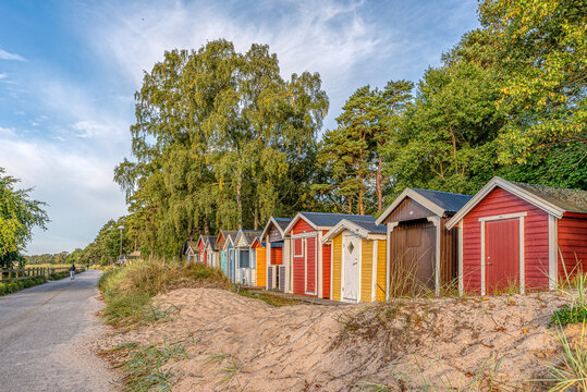 scenic beach huts in a row in the sand close to the sea