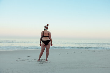 Unrecognizable female winter bather standing at the beach