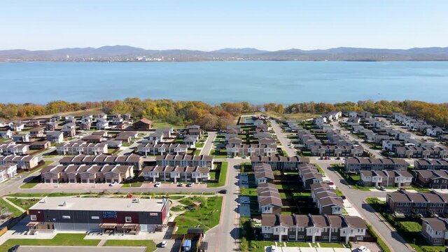 Autumn, 2021 - Vladivostok, Russia - New cottage village near Vladivostok. View from above. New townhouses are in a row against the backdrop of the sea.