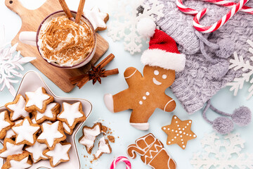 Gingerbread man, cookies and Christmas decor on pastel background.