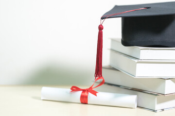 Close-up of a mortarboard and degree certificate on the table. Education Concept Stock Photo