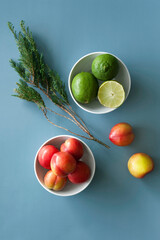 Fresh limes and plums on blue background