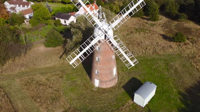Billingford Windmill at a farm land area with house in Diss, Norfolk - aerial drone flying backward shot