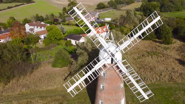 Flying over Billingford Windmill at a farmland area with house in Diss, Norfolk - aerial drone backward shot