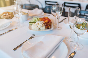 Table arrangement in the restaurant, light snacks in the background, wedding table preparation