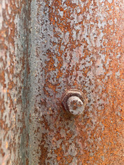 Bolt and nut on rusty brown iron plane, background