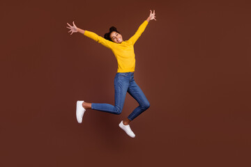 Fototapeta na wymiar Full body photo of cool teen girl jump wear shirt jeans sneakers isolated on brown color background