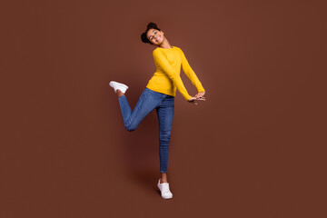Fototapeta na wymiar Full length photo of teenager girl dance wear sweater jeans shoes isolated on brown color background