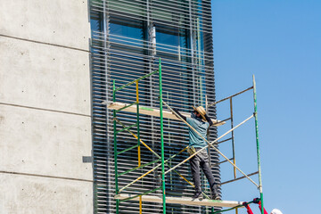 Man working repairing high-rise building windows