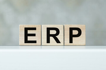 Three wooden cubes with letters ERP - stands for Enterprise Resource Planning on a light table