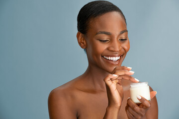 Black mid adult woman applying cream on face