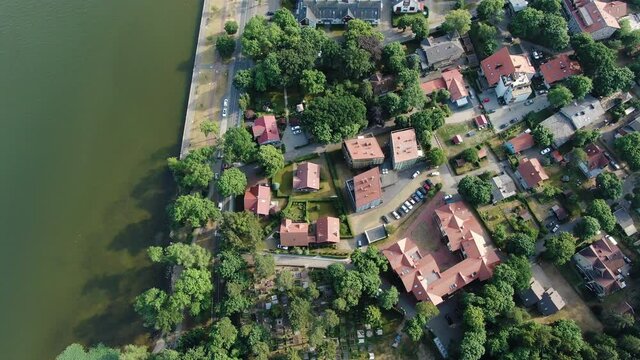 Juokrante town with moving vehicle and people, aerial top down view