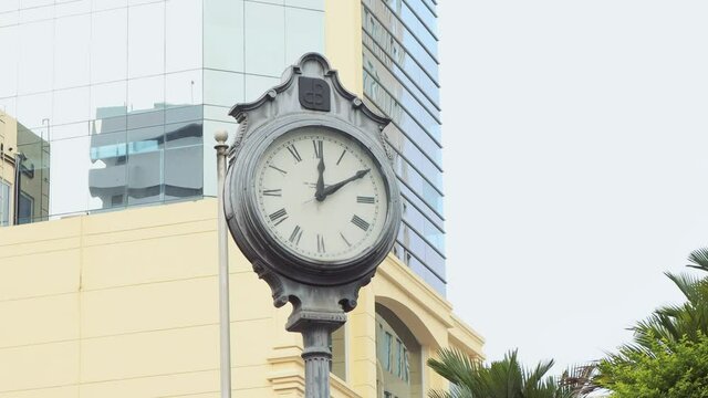 4K footage of a large analogue clock as a post marking ten minutes past twelve installed in the streets of Panama City.