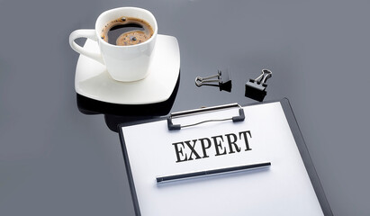 EXPERT text on paper sheet with coffee on the black background