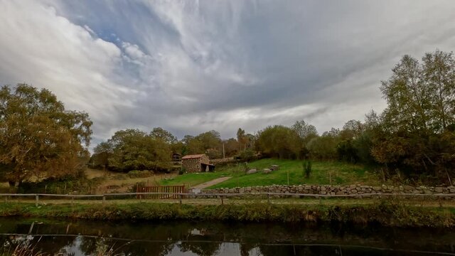 Traveling side view of beautiful grassy corner in Branda de Aveleda, Portugal with meadow house and trees on a cloudy day, Parque Nacional da Peneda Geres, Portugal.