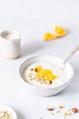 Fresh porridge on nut milk with baked oranges, orange jam and nuts on a gray background. Healthy breakfast, healthy food