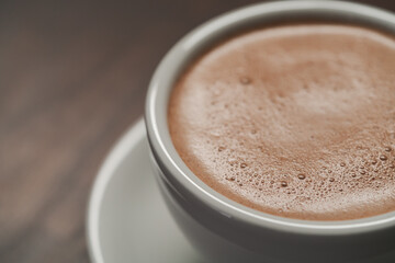 closeup of hot cocoa drink on walnut wood table