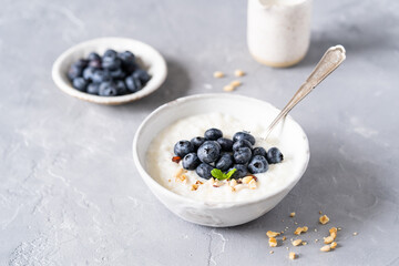 Rice porridge on coconut milk with blueberries on a gray background. Healthy breakfast, healthy food