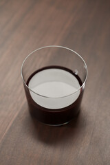 Red wine in tumbler glass on a walnut table with copy space