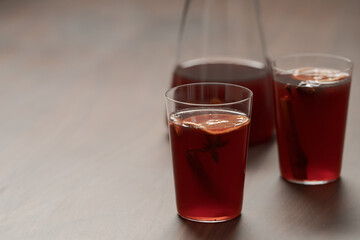 Mulled wine in tumbler glasses on walnut table with copy space